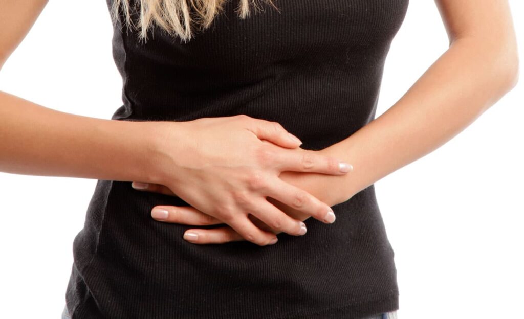 Eine Frau, die sich den Bauch hält, sie hat Darmbeschwerden